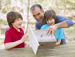 Image of father and children building a birdhouse