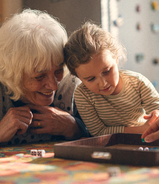 Woman playing board game with grand-daughter